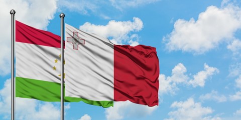 Tajikistan and Malta flag waving in the wind against white cloudy blue sky together. Diplomacy concept, international relations.