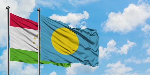 Tajikistan and Palau flag waving in the wind against white cloudy blue sky together. Diplomacy concept, international relations.