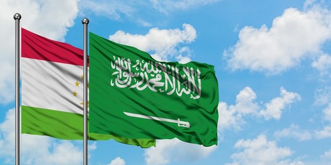 Tajikistan and Saudi Arabia flag waving in the wind against white cloudy blue sky together. Diplomacy concept, international relations.