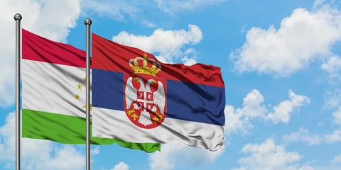 Tajikistan and Serbia flag waving in the wind against white cloudy blue sky together. Diplomacy concept, international relations.