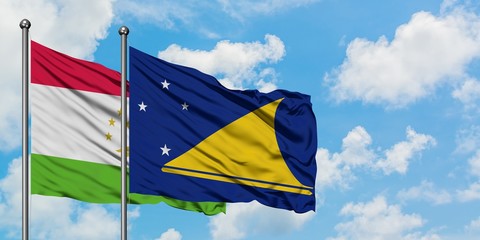 Tajikistan and Tokelau flag waving in the wind against white cloudy blue sky together. Diplomacy concept, international relations.