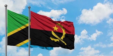 Tanzania and Angola flag waving in the wind against white cloudy blue sky together. Diplomacy concept, international relations.