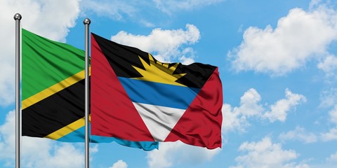 Tanzania and Antigua and Barbuda flag waving in the wind against white cloudy blue sky together. Diplomacy concept, international relations.