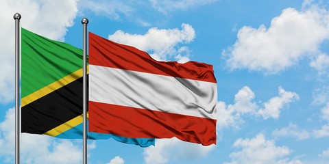 Tanzania and Austria flag waving in the wind against white cloudy blue sky together. Diplomacy concept, international relations.