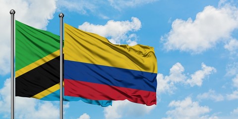 Tanzania and Colombia flag waving in the wind against white cloudy blue sky together. Diplomacy concept, international relations.