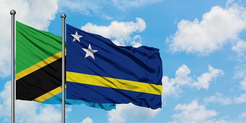 Tanzania and Curacao flag waving in the wind against white cloudy blue sky together. Diplomacy concept, international relations.