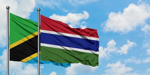 Tanzania and Gambia flag waving in the wind against white cloudy blue sky together. Diplomacy concept, international relations.