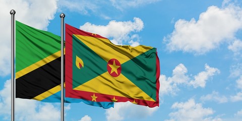 Tanzania and Grenada flag waving in the wind against white cloudy blue sky together. Diplomacy concept, international relations.