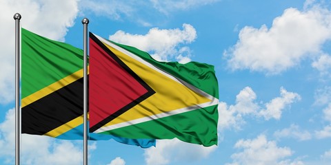 Tanzania and Guyana flag waving in the wind against white cloudy blue sky together. Diplomacy concept, international relations.