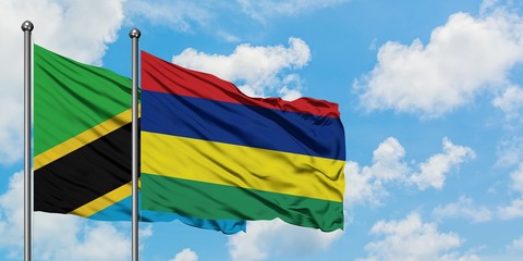 Tanzania and Mauritius flag waving in the wind against white cloudy blue sky together. Diplomacy concept, international relations.