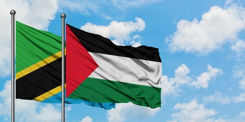 Tanzania and Palestine flag waving in the wind against white cloudy blue sky together. Diplomacy concept, international relations.