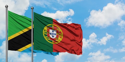Tanzania and Portugal flag waving in the wind against white cloudy blue sky together. Diplomacy concept, international relations.