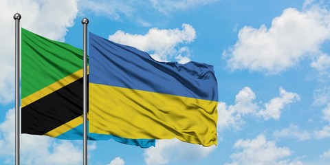 Tanzania and Ukraine flag waving in the wind against white cloudy blue sky together. Diplomacy concept, international relations.