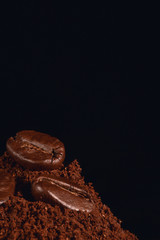 coffee background of roasted coffee beans on grounded coffee on dark background