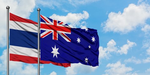 Thailand and Australia flag waving in the wind against white cloudy blue sky together. Diplomacy concept, international relations.