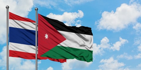 Thailand and Jordan flag waving in the wind against white cloudy blue sky together. Diplomacy concept, international relations.