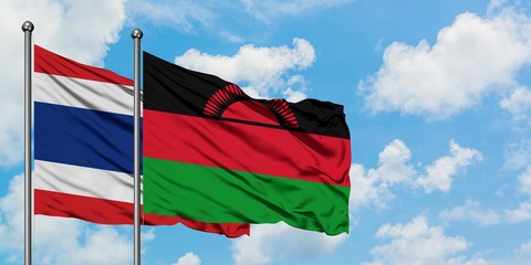 Thailand and Malawi flag waving in the wind against white cloudy blue sky together. Diplomacy concept, international relations.