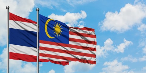 Thailand and Malaysia flag waving in the wind against white cloudy blue sky together. Diplomacy concept, international relations.