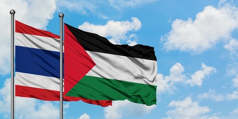Thailand and Palestine flag waving in the wind against white cloudy blue sky together. Diplomacy concept, international relations.