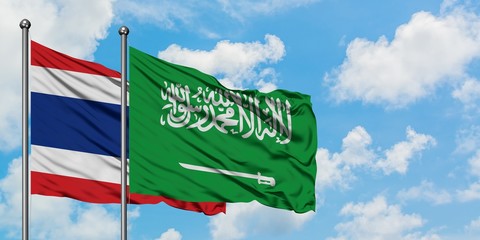 Thailand and Saudi Arabia flag waving in the wind against white cloudy blue sky together. Diplomacy concept, international relations.