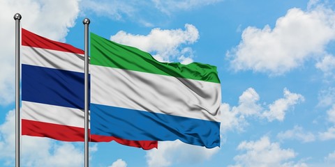 Thailand and Sierra Leone flag waving in the wind against white cloudy blue sky together. Diplomacy concept, international relations.