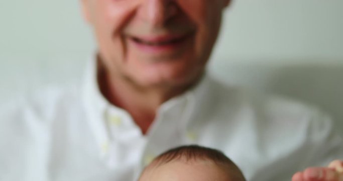 Authentic candid grandfather holding newborn grandson smiling