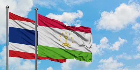 Thailand and Tajikistan flag waving in the wind against white cloudy blue sky together. Diplomacy concept, international relations.