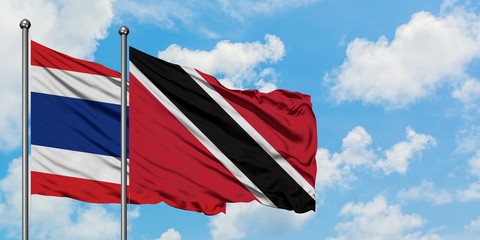 Thailand and Trinidad And Tobago flag waving in the wind against white cloudy blue sky together. Diplomacy concept, international relations.