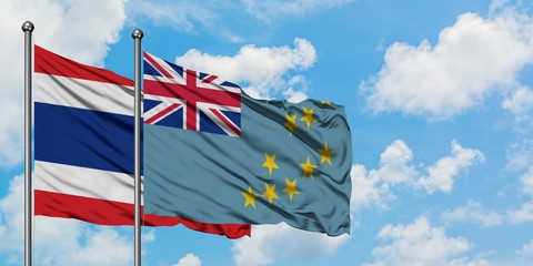 Thailand and Tuvalu flag waving in the wind against white cloudy blue sky together. Diplomacy concept, international relations.