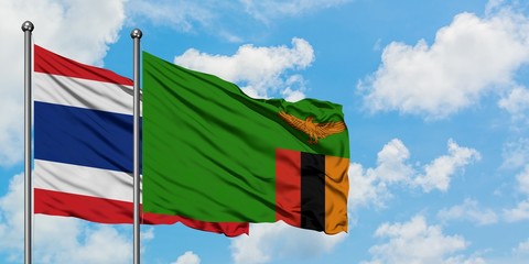 Thailand and Zambia flag waving in the wind against white cloudy blue sky together. Diplomacy concept, international relations.