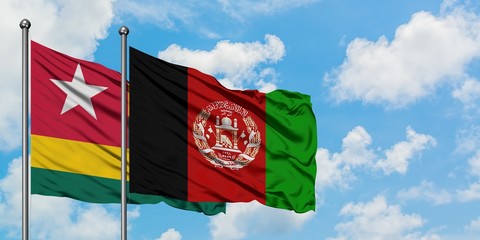 Togo and Afghanistan flag waving in the wind against white cloudy blue sky together. Diplomacy concept, international relations.