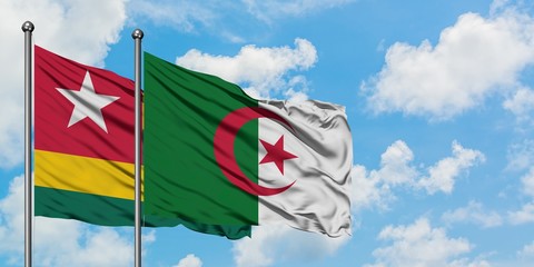 Togo and Algeria flag waving in the wind against white cloudy blue sky together. Diplomacy concept, international relations.