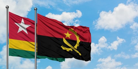 Togo and Angola flag waving in the wind against white cloudy blue sky together. Diplomacy concept, international relations.
