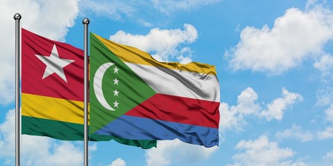 Togo and Comoros flag waving in the wind against white cloudy blue sky together. Diplomacy concept, international relations.