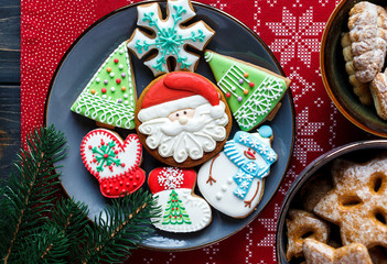 Homemade gingerbreads on plate on wooden background. Holidays and celebration concept, greeting card mockup, festive decoration. Christmas and New Year composition.