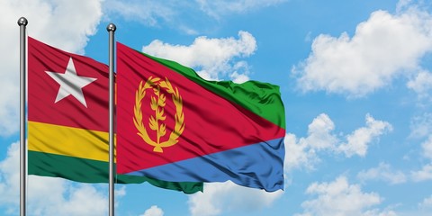 Togo and Eritrea flag waving in the wind against white cloudy blue sky together. Diplomacy concept, international relations.