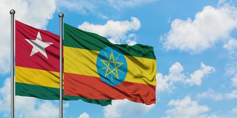 Togo and Ethiopia flag waving in the wind against white cloudy blue sky together. Diplomacy concept, international relations.