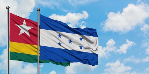 Togo and Honduras flag waving in the wind against white cloudy blue sky together. Diplomacy concept, international relations.