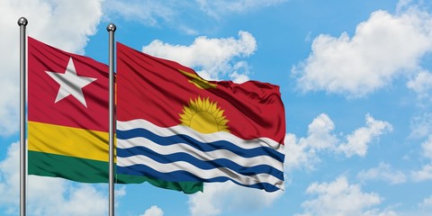 Togo and Kiribati flag waving in the wind against white cloudy blue sky together. Diplomacy concept, international relations.