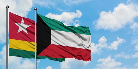 Togo and Kuwait flag waving in the wind against white cloudy blue sky together. Diplomacy concept, international relations.