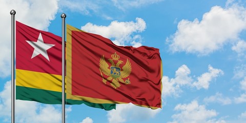 Togo and Montenegro flag waving in the wind against white cloudy blue sky together. Diplomacy concept, international relations.