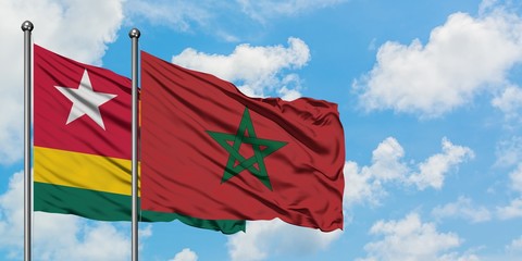 Togo and Morocco flag waving in the wind against white cloudy blue sky together. Diplomacy concept, international relations.