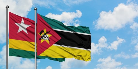 Togo and Mozambique flag waving in the wind against white cloudy blue sky together. Diplomacy concept, international relations.