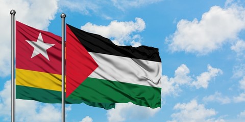 Togo and Palestine flag waving in the wind against white cloudy blue sky together. Diplomacy concept, international relations.