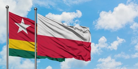 Togo and Poland flag waving in the wind against white cloudy blue sky together. Diplomacy concept, international relations.