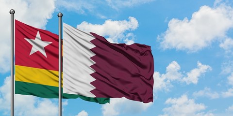 Togo and Qatar flag waving in the wind against white cloudy blue sky together. Diplomacy concept, international relations.