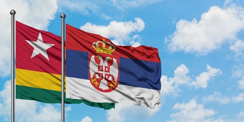 Togo and Serbia flag waving in the wind against white cloudy blue sky together. Diplomacy concept, international relations.