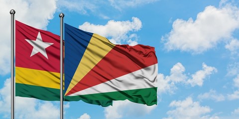 Togo and Seychelles flag waving in the wind against white cloudy blue sky together. Diplomacy concept, international relations.
