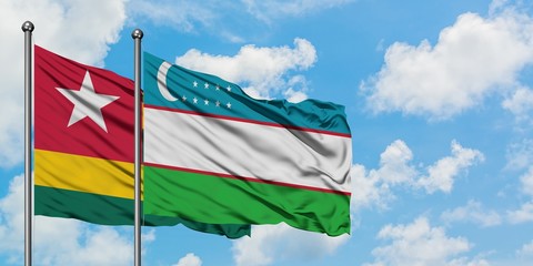 Togo and Uzbekistan flag waving in the wind against white cloudy blue sky together. Diplomacy concept, international relations.