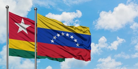 Togo and Venezuela flag waving in the wind against white cloudy blue sky together. Diplomacy concept, international relations.